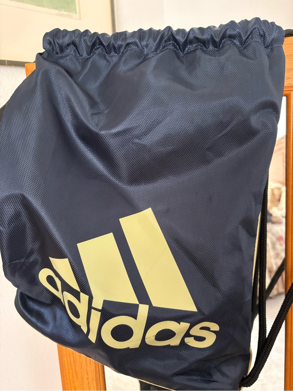 adidas navy blue drawstring backpack with pale yellow logo